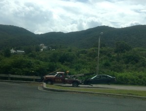 Towing (or in this case, 'carrying') the wheel-less car. 